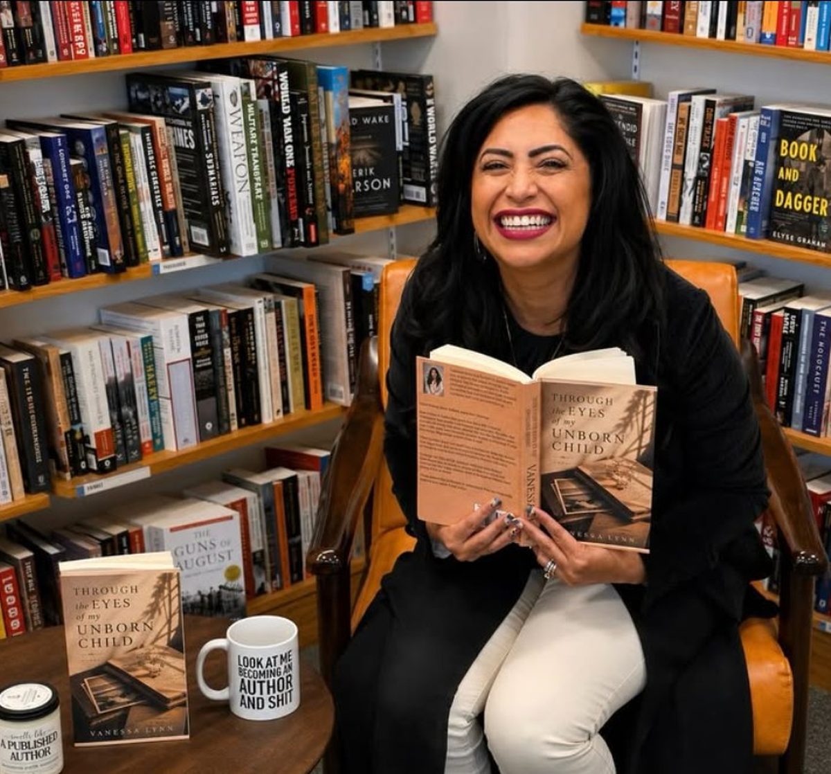 Vanessa Lynn holding Through the Eyes of My Unborn Child at a bookstore